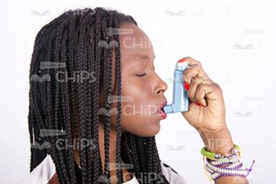 Young African Woman Using Inhaler Profile View Stock Photo-0