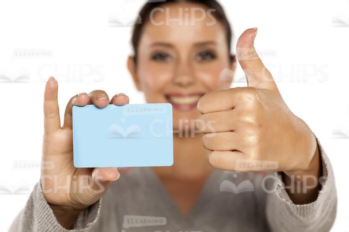 Smiling Woman Holding Card Sample And Showing Her Thumb Up Stock Photo-0