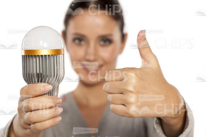 Nice Girl With LED Light Bulb Showing Thumb Up Stock Photo-0