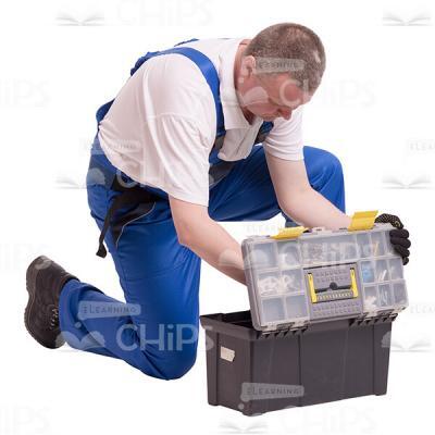 Middle-aged Builder Kneeling and Looking into a Toolbox Cutout Photo-0