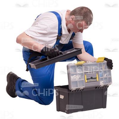Cutout Photo of Middle-aged Builder Kneeling and Drawing Something out of the Toolbox-0