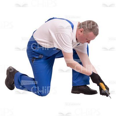 Cutout Photo of Focused Builder Kneeling and Screwing on-0