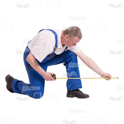 Cutout Image of Middle-aged Builder Kneeling and Using Measuring Tape-0